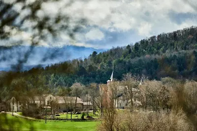 a house in a field with a church on a hill at Château de Sibra in Lagarde