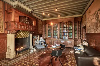 a living room with a fireplace and a couch at Château de Sibra in Lagarde