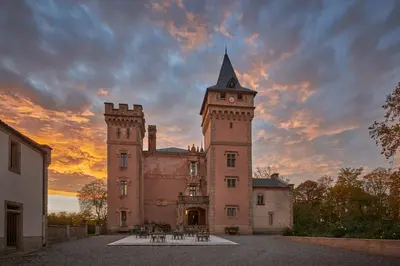 a building with a clock tower with a sunset in the background at Château de Sibra in Lagarde