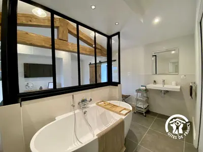 a bathroom with a large tub and a sink at Le mas de l'ecluse in Caux-et-Sauzens