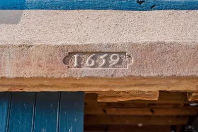 a stone sign on the side of a building at Le mas de l'ecluse in Caux-et-Sauzens