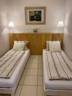 two beds in a small room with two lamps at Gîte - Le Relais d'Affiac in Peyriac-Minervois