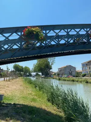a bridge with flowers on it over a river at Gîte - Le Relais d'Affiac in Peyriac-Minervois