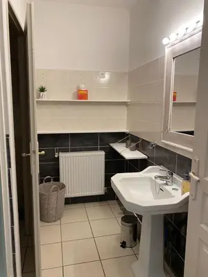 a white bathroom with a sink and a mirror at Gîte - Le Relais d'Affiac in Peyriac-Minervois