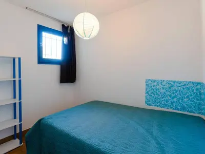 a bedroom with a blue bed and a window at T2 avec Piscine à Gruissan - Proche Plage et Commerces - FR-1-409A-14 in Gruissan