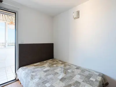 a bedroom with a bed and a large window at Appartement Gruissan - Parking Privé, Animaux Acceptés - FR-1-409A-16 in Gruissan