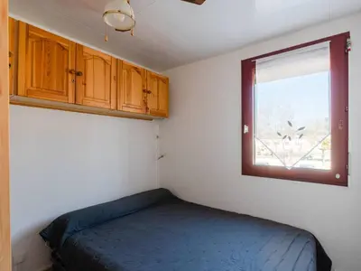 a small bedroom with a bed and a window at Appartement lumineux à Gruissan, 2 chambres, proche plage, parking sécurisé, mini-box WIFI, non-fumeur - FR-1-409A-15 in Gruissan