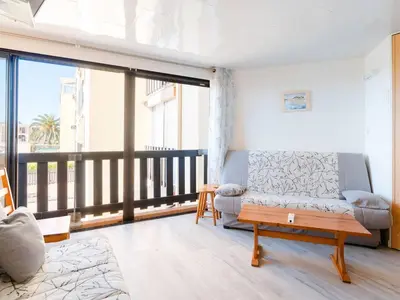 a living room with a couch and a balcony at Appartement lumineux à Gruissan, 2 chambres, proche plage, parking sécurisé, mini-box WIFI, non-fumeur - FR-1-409A-15 in Gruissan