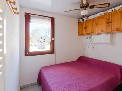 a bedroom with a purple bed and a window at Appartement lumineux à Gruissan, 2 chambres, proche plage, parking sécurisé, mini-box WIFI, non-fumeur - FR-1-409A-15 in Gruissan
