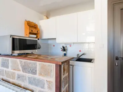 a kitchen with a counter with a microwave and a sink at Appartement lumineux à Gruissan, 2 chambres, proche plage, parking sécurisé, mini-box WIFI, non-fumeur - FR-1-409A-15 in Gruissan