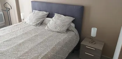 a bedroom with a bed with pillows and a night stand at Chez Reinette in Capendu