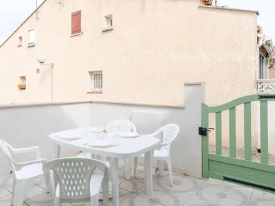 a white table and chairs on a balcony at Chaleureuse Villa à Gruissan - 6 pers, Près de la Plage, Garage, Cuisine Équipée, Confort Moderne - FR-1-409A-17 in Gruissan