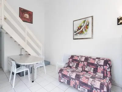 a living room with a couch and a table and stairs at Chaleureuse Villa à Gruissan - 6 pers, Près de la Plage, Garage, Cuisine Équipée, Confort Moderne - FR-1-409A-17 in Gruissan