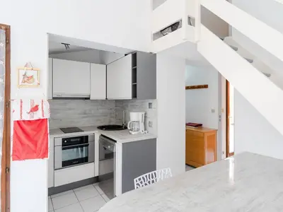 a kitchen with white cabinets and a counter top at Chaleureuse Villa à Gruissan - 6 pers, Près de la Plage, Garage, Cuisine Équipée, Confort Moderne - FR-1-409A-17 in Gruissan