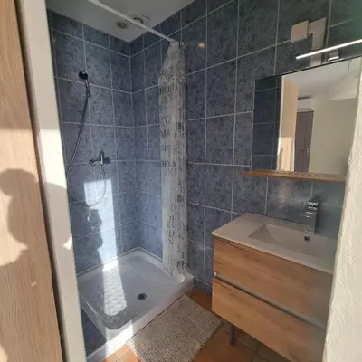 a bathroom with a shower and a sink at Chambre avec piscine partagée in Marcorignan