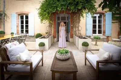 a woman standing in the doorway of a building at La Chasse au Bonheur Piscine-Wifi in Rieux-Minervois