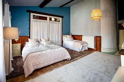 a bedroom with two beds and a lamp at La Chasse au Bonheur Piscine-Wifi in Rieux-Minervois