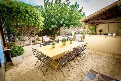 a table and chairs sitting on a patio at La Chasse au Bonheur Piscine-Wifi in Rieux-Minervois