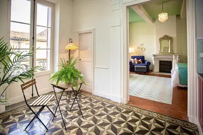 a hallway with a living room with a fireplace at La Chasse au Bonheur Piscine-Wifi in Rieux-Minervois