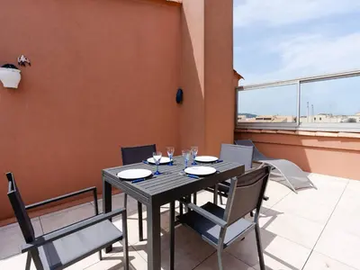 a black table and chairs on a balcony with a window at Duplex lumineux à Gruissan avec parking, proche plage et port - FR-1-409A-11 in Gruissan
