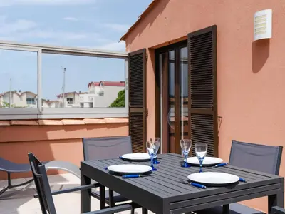 a black table with chairs and glasses on a balcony at Duplex lumineux à Gruissan avec parking, proche plage et port - FR-1-409A-11 in Gruissan
