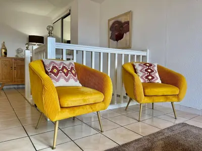 two yellow chairs sitting in a living room at Duplex 70m2 - Vue Cité Mediévale - Parking gratuit in Carcassonne