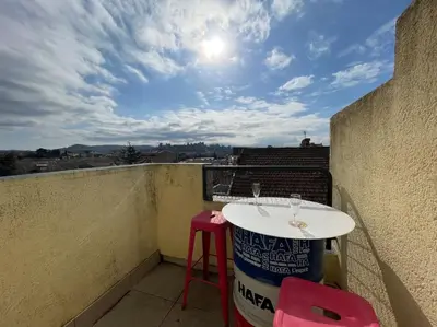 a table and stool on a balcony with a view at Duplex 70m2 - Vue Cité Mediévale - Parking gratuit in Carcassonne