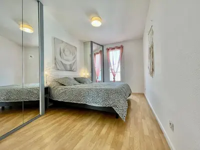 a bedroom with a bed and a mirror at Duplex 70m2 - Vue Cité Mediévale - Parking gratuit in Carcassonne