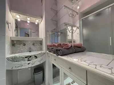 a bathroom with a sink and a large mirror at Duplex 70m2 - Vue Cité Mediévale - Parking gratuit in Carcassonne