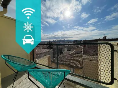 a balcony with two chairs and a car on a roof at Duplex 70m2 - Vue Cité Mediévale - Parking gratuit in Carcassonne
