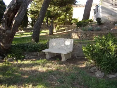 a bench sitting in the grass under a tree at Londres guest room in the heart of the vineyard no123 in Badens