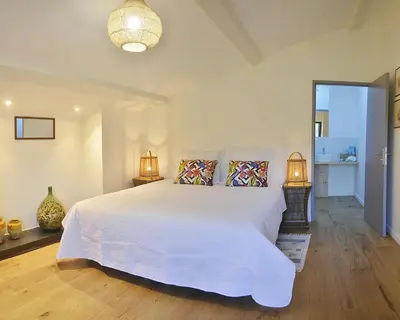 a bedroom with a large white bed and two lamps at L'écurie de Gamin - gîte 4 pers. dans le Minervois in Aigues-Vives