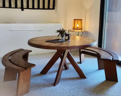 a wooden table with a lamp and a chair at L'écurie de Gamin - gîte 4 pers. dans le Minervois in Aigues-Vives