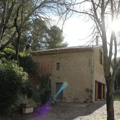 a stone building with a blue door in front of it at L'écurie de Gamin - gîte 4 pers. dans le Minervois in Aigues-Vives