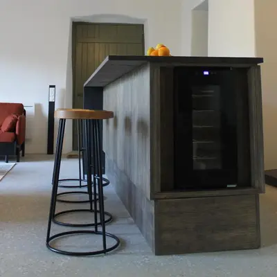 a wooden entertainment center with a stool and a television at L'écurie de Gamin - gîte 4 pers. dans le Minervois in Aigues-Vives