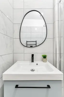 a white bathroom with a sink and a mirror at les Bulles Occitanes - tout à pied in Carcassonne