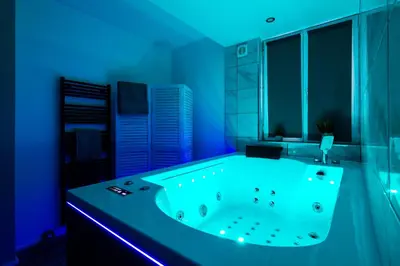 a bathroom with a large tub with blue lighting at les Bulles Occitanes - tout à pied in Carcassonne