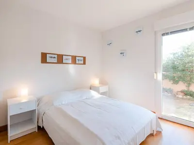 a white bedroom with a bed and a window at Villa spacieuse à Gruissan, 4 chambres, jardin privé, clim, proche plage, idéal familles/amis - FR-1-409A-18 in Gruissan