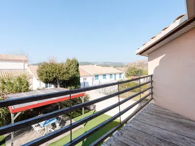 a balcony with a view of a building at Villa spacieuse à Gruissan, 4 chambres, jardin privé, clim, proche plage, idéal familles/amis - FR-1-409A-18 in Gruissan