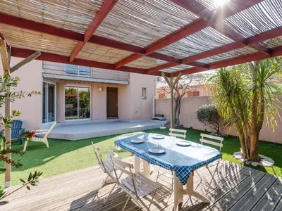 a patio with a table and chairs under a pergola at Villa spacieuse à Gruissan, 4 chambres, jardin privé, clim, proche plage, idéal familles/amis - FR-1-409A-18 in Gruissan