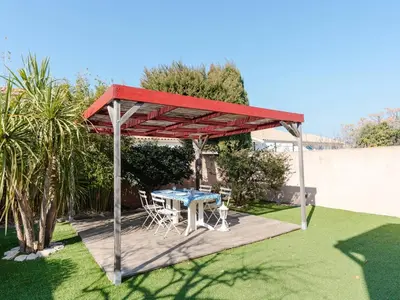 a picnic table under a pavilion in a garden at Villa spacieuse à Gruissan, 4 chambres, jardin privé, clim, proche plage, idéal familles/amis - FR-1-409A-18 in Gruissan