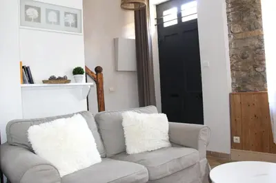 a living room with a gray couch and a black door at La Cité Secrète in Carcassonne