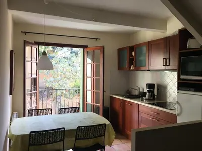 a kitchen with a table and chairs and a window at La Parenthèse in Tautavel