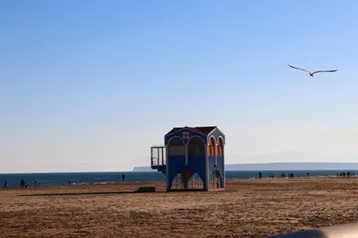 a lifeguard tower on a beach with the ocean in the background at Agréable Studio en bord de mer in Port-la-Nouvelle