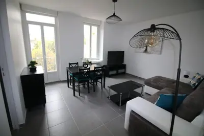 a bedroom with a bed with two pillows and two lamps at NARBONNE : SUPER APPARTEMENT DE QUALITÉ in Narbonne