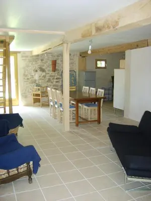 a living room with a table and some chairs at Gîte Le Ribet in Lempaut