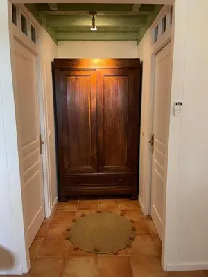 a hallway with a wooden door and a rug at LAURAGUEL CHAMBRES D'HÔTES in Mourvilles-Hautes