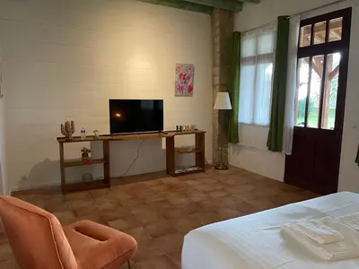 a room with a bed and a television on a table at LAURAGUEL CHAMBRES D'HÔTES in Mourvilles-Hautes