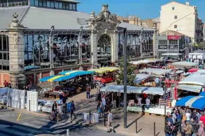 a group of people walking around a market in front of a building at Soleil Sucré T2 Centre historique de Narbonne in Narbonne