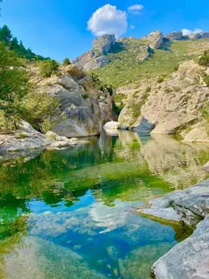 a body of water in a mountain with rocks and blue at Soleil Sucré T2 Centre historique de Narbonne in Narbonne